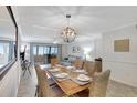 Bright dining room with table, chairs, and chandelier, offering ocean view at 1200 E Peppertree Ln # 607, Sarasota, FL 34242