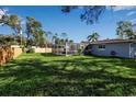 Large backyard with grassy area and screened pool at 20378 Emerald Ave, Port Charlotte, FL 33952