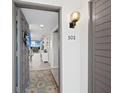 Entryway with tiled floor, gray door, and coastal decor, leading to the living area at 2045 Gulf Of Mexico Dr # M1-502, Longboat Key, FL 34228