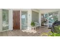 Inviting front porch with tile flooring, seating area and decorative door at 350 Gulf Of Mexico Dr # 211, Longboat Key, FL 34228