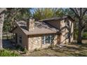 Two-story house with stone and wood siding, a brown door, and large windows at 6919 64Th E Ave, Palmetto, FL 34221