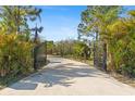 Long driveway leading to a home with black metal gates at 8139 Alan Blvd, Punta Gorda, FL 33982