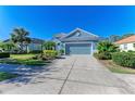 Inviting blue single-story home with a two-car garage and manicured landscaping at 1387 Still River Dr, Venice, FL 34293