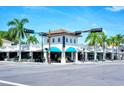 A vibrant street view showcasing a commercial building with blue awnings and swaying palm trees at 1732 Hillview St, Sarasota, FL 34239