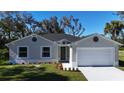 Charming single-story home with a well-manicured lawn, attached two-car garage, and a freshly painted exterior at 1859 Lamont St, North Port, FL 34288