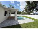 The backyard features a sparkling pool, a covered patio, and a stylish deck for outdoor enjoyment and relaxation at 1859 Lamont St, North Port, FL 34288
