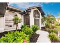 Front entrance with a screened porch and nicely landscaped walkway at 301 Gold Tree, Punta Gorda, FL 33955