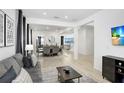 Open living room with dining area, large TV, and gray couch at 33443 Landsman Loop, Wesley Chapel, FL 33543