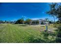 Large grassy backyard with screened pool and trees at 36 Santarem Cir, Punta Gorda, FL 33983