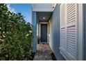 Front walkway leads to a dark entryway door with white shutters at 4151 Via Sienna Cir, Sarasota, FL 34243