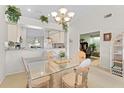 Bright dining room with glass table and view into kitchen and office at 6908 Drewrys Blf # 711, Bradenton, FL 34203