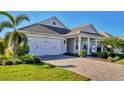 Two-story house with gray siding, a white front door and a paved driveway at 8089 Sandstar Way, Sarasota, FL 34240