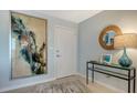 Bright condo entryway with modern decor, featuring a large abstract painting and console table at 101 Benjamin Franklin Dr # 54, Sarasota, FL 34236