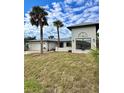 Modern home exterior with palm trees, a two-car garage, and large lawn at 1798 Dagon Rd, Venice, FL 34293