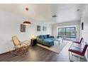 Bright living room with modern furnishings, wood floors, and sliding doors to a balcony with a green view at 2124 N Tamiami Trl # 103, Sarasota, FL 34234