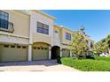 Tan townhouses with attached garages and manicured hedges at 4046 Overture Cir # 4046, Bradenton, FL 34209