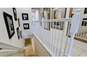 Elegant staircase with a white railing and framed Gathering photos at 4046 Overture Cir # 4046, Bradenton, FL 34209