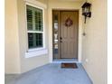 Front porch with brown door, window with shutters, and a welcome mat at 5613 Key Largo Ct, Bradenton, FL 34203
