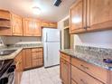 Light wood cabinets, granite counters, and stainless steel appliances at 5889 Garden Ln # H4, Bradenton, FL 34207