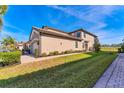 Tan house with a garage and walkway, surrounded by lush landscaping at 6035 Worsham Ln # 104, Lakewood Ranch, FL 34211