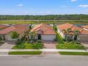 Community view showcasing houses with tile roofs and lush landscaping at 10141 Colubrina Dr, Venice, FL 34293