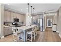 Modern kitchen featuring stainless steel appliances, a large island with seating, and ample counter space at 11265 Mc Dermott Ct, Englewood, FL 34223