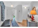 Welcoming entryway with light wood flooring, a bench, and decorative accents at 1720 Starling Dr # 103, Sarasota, FL 34231