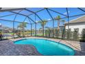 Inviting screened-in pool area with brick pavers and a beautiful view of the surrounding landscaping at 17744 Savory Mist Cir, Bradenton, FL 34211
