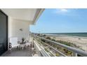 Balcony view of a condo with chairs and white railings overlooking the white sands and ocean at 2105 Gulf Of Mexico Dr # 3303, Longboat Key, FL 34228