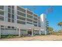 Low angle shot of white apartment building exterior with palm trees and manicured landscaping at 2105 Gulf Of Mexico Dr # 3303, Longboat Key, FL 34228