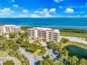 Waterfront condo building with lush landscaping and parking at 3070 Grand Bay Blvd # 612, Longboat Key, FL 34228