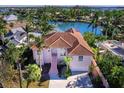 Aerial view of waterfront home with canal access, lush landscaping, and a private dock at 508 Siesta Dr, Sarasota, FL 34242