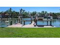 Waterfront home featuring boat dock with boat lift and lush green lawn at 508 Siesta Dr, Sarasota, FL 34242
