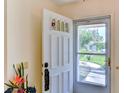 White front door with sidelights and a storm door, view to yard at 5604 Garden Lakes Dr, Bradenton, FL 34203