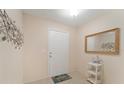 Welcoming entryway with neutral walls, white door, and decorative mirror at 607 Marcus St # 27, Venice, FL 34285