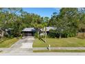 Quaint Florida home with a screened-in front porch and lush landscaping at 2669 Prospect St, Sarasota, FL 34239