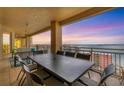 Spacious balcony with outdoor dining furniture and stunning water views at sunset at 35 Watergate Dr # 1203, Sarasota, FL 34236