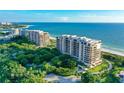 Aerial view of two luxury beachfront buildings and lush landscaping at 435 L Ambiance Dr # M408, Longboat Key, FL 34228