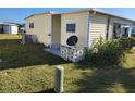 Side view of a yellow single-wide manufactured home with a satellite dish at 5414 Burma Ct, Bradenton, FL 34207