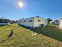 Rear view of a yellow single-wide manufactured home on a grassy lot at 5414 Burma Ct, Bradenton, FL 34207