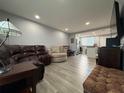 Living room with brown leather furniture, wood floors, recessed lighting, and an open view into the kitchen at 628 Cohen Way # 628, Sarasota, FL 34236