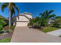 Well-maintained house featuring a paver driveway and tropical landscaping at 7223 Orchid Island Pl, Bradenton, FL 34202