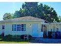 House with a carport and a large tree in front at 3310 Lexington St, Sarasota, FL 34231