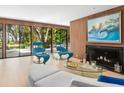 Cozy living room with a fireplace, comfortable seating, and large windows overlooking the greenery at 3348 Old Oak Dr, Sarasota, FL 34239
