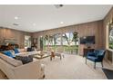 Open living room with wood paneling, plush seating, and waterfront views at 3350 Old Oak Dr, Sarasota, FL 34239