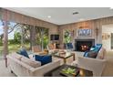 Stylish living room with wood paneling, fireplace, and large windows at 3350 Old Oak Dr, Sarasota, FL 34239