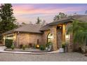 Brick home with landscaped entryway, featuring lighting and modern design at 5706 Bent Oak Dr, Sarasota, FL 34232