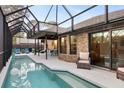 A screened-in pool area featuring a pool, patio seating, and a view of the home's exterior at 5706 Bent Oak Dr, Sarasota, FL 34232