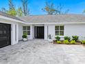 Contemporary front entry with black door and gray pavers at 749 Tropical Cir, Sarasota, FL 34242