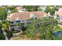 A condo complex surrounded by green spaces, including trees and a picturesque pond at 850 S Tamiami Trl # 227, Sarasota, FL 34236